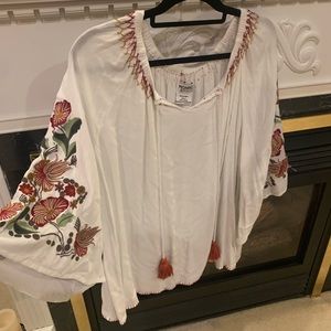 Bohemian flare! Embellished sleeves with sewn on flowers and drawstring neck
